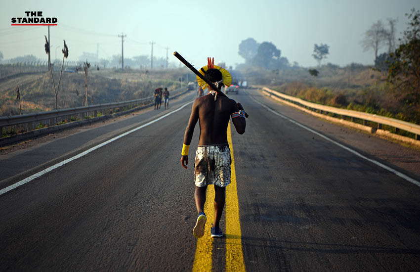 ชายชาติพันธุ์คายาโป เดินกลางถนนสาย BR163 ในรัฐปาราของบราซิล เมื่อวันที่ 17 สิงหาคม เพื่อประท้วงรัฐบาลที่ไม่ช่วยเยียวยาชนกลุ่มน้อยในช่วงที่เกิดโรคระบาดโควิด-19