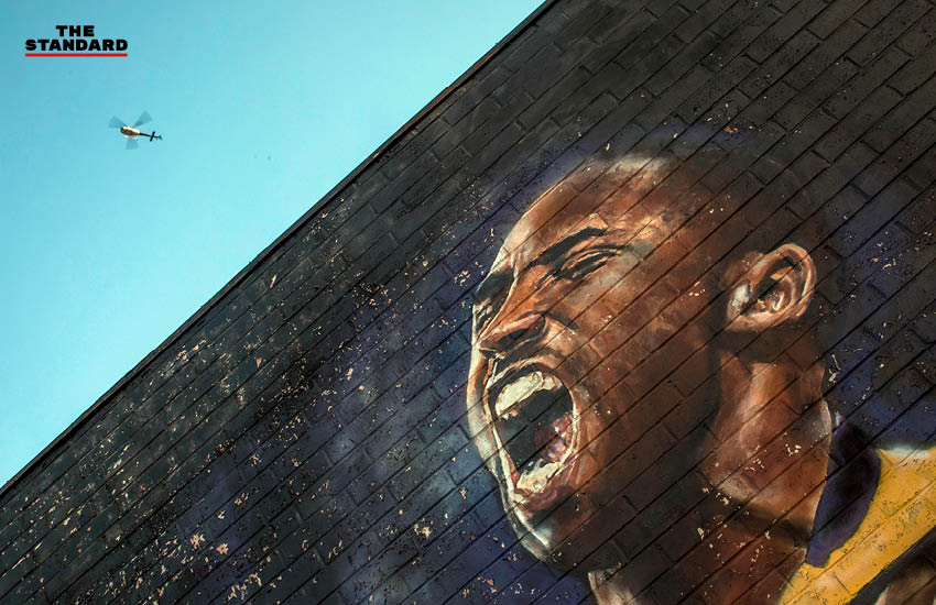 เฮลิคอปเตอร์บินอยู่เหนือกำแพงที่มีรูปของ โคบี ไบรอันต์ นักบาสเกตบอลระดับตำนานของ NBA ในย่านดาวน์ทาวน์ นครลอสแอนเจลิส