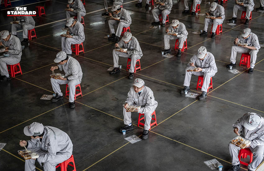พนักงานนั่งรับประทานอาหารกลางวันแบบเว้นระยะห่างในโรงงานรถยนต์ตงฟงฮอนด้า ในเมืองอู่ฮั่น มณฑลหูเป่ย เมื่อวันที่ 23 มีนาคม