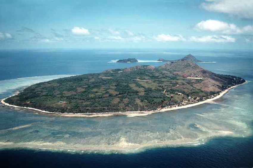 Mer or Murray Island and the smaller islands of Dawar and Waier behind it, in the eastern Torres Strait Islands. The island is a high rocky island with the reef around it clearly visible.