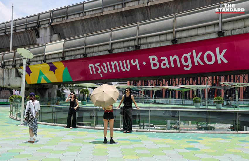 นักท่องเที่ยวถ่ายภาพกับป้าย Bangkok บนสกายวอล์กแยกปทุมวัน แม้จำนวนลดลงแต่ยังคงมีผู้มาเยี่ยมชมอย่างต่อเนื่อง