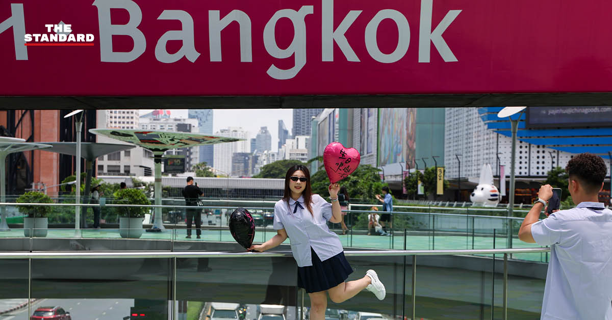 นักท่องเที่ยวถ่ายภาพกับป้าย Bangkok บนสกายวอล์กแยกปทุมวัน แม้จำนวนลดลงแต่ยังคงมีผู้มาเยี่ยมชมอย่างต่อเนื่อง