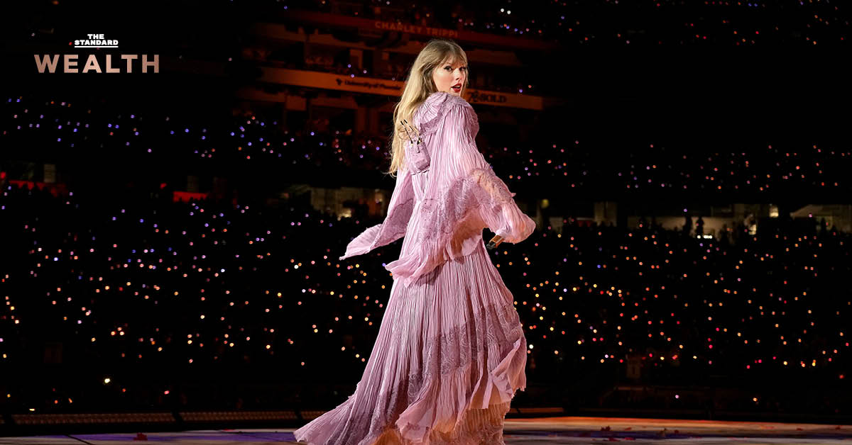 Taylor Swift ยืนอยู่บนเวที Eras Tour พร้อมข้อความ "เธอได้สิทธิ์เพลงคืน ครองอาณาจักรดนตรีของตัวเอง"