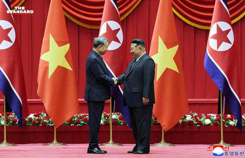 คิม จองอึน และ โต เลิม ยืนจับมือกัน