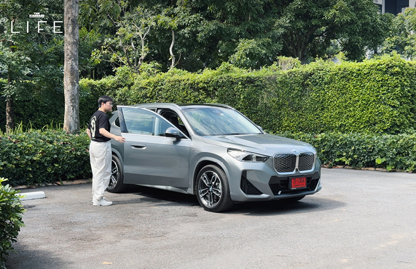 BMW iX1 L สีขาวหรือสีฟ้าที่จอดอยู่ในเมือง