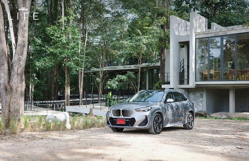 BMW iX1 L สีขาวหรือสีฟ้าที่จอดอยู่ในเมือง