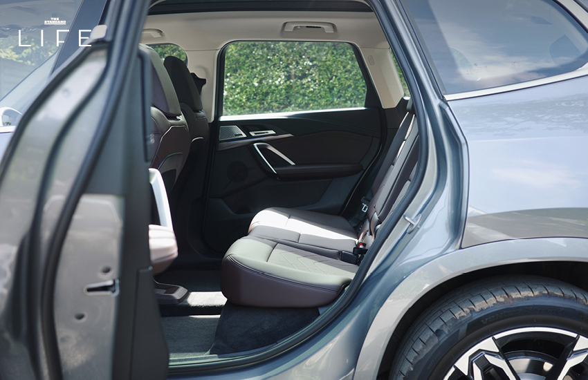 BMW iX1 L สีขาวหรือสีฟ้าที่จอดอยู่ในเมือง