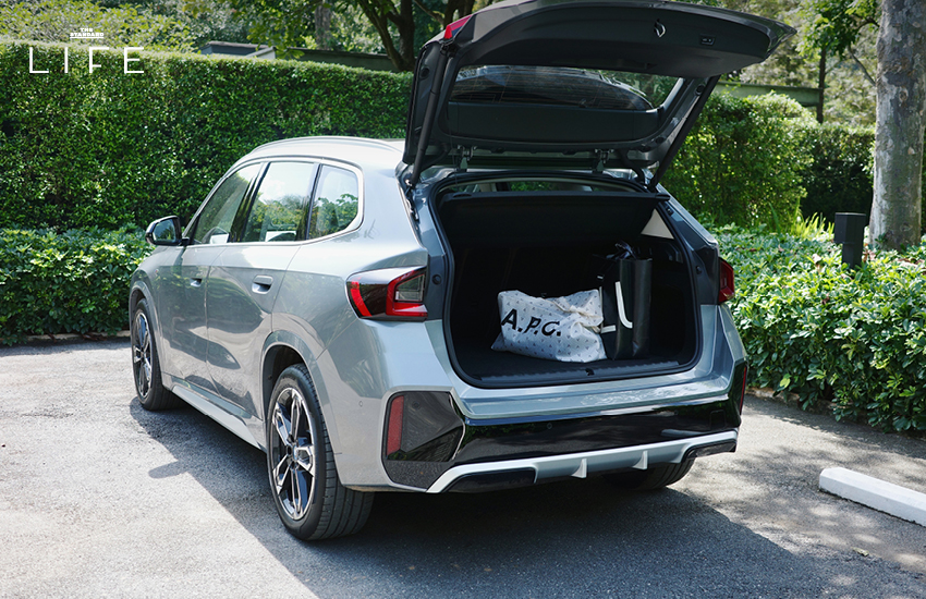 BMW iX1 L สีขาวหรือสีฟ้าที่จอดอยู่ในเมือง