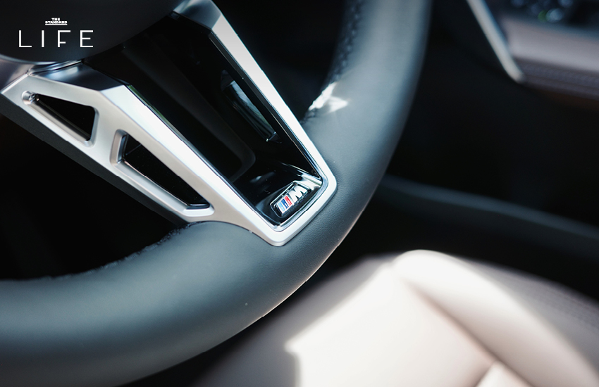 BMW iX1 L สีขาวหรือสีฟ้าที่จอดอยู่ในเมือง