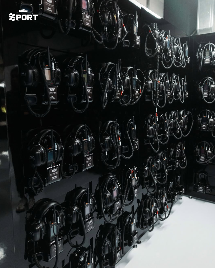 ภาพการแต่งกายของนักแข่งทีม Cadillac F1 พร้อมอุปกรณ์และโลโก้ทีมที่แสดงถึงสไตล์และความหรูหรา 4