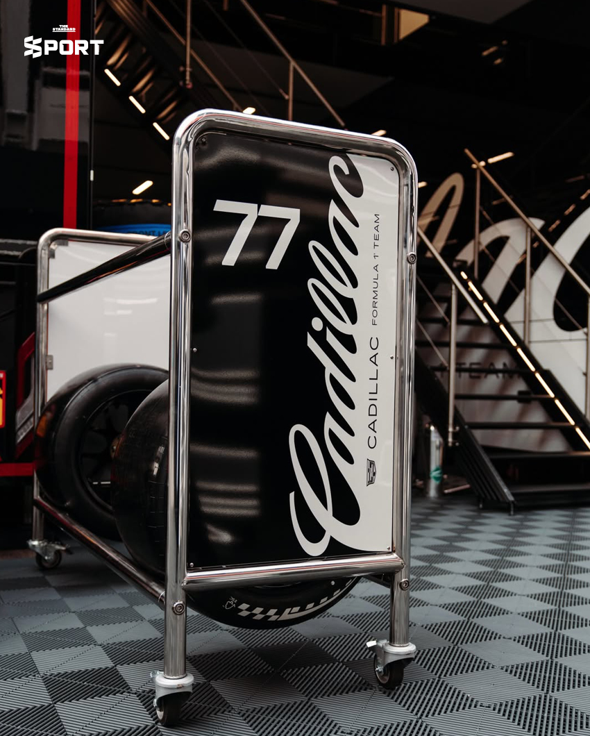 ภาพการแต่งกายของนักแข่งทีม Cadillac F1 พร้อมอุปกรณ์และโลโก้ทีมที่แสดงถึงสไตล์และความหรูหรา 5