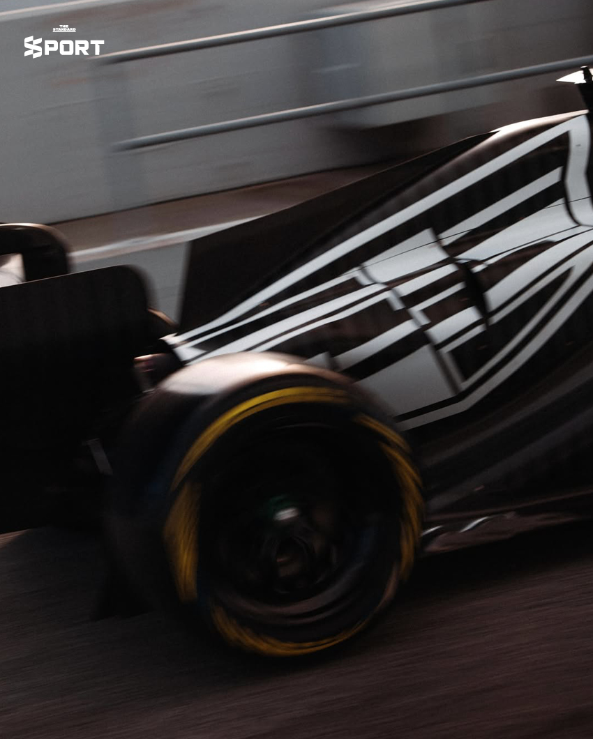 ภาพการแต่งกายของนักแข่งทีม Cadillac F1 พร้อมอุปกรณ์และโลโก้ทีมที่แสดงถึงสไตล์และความหรูหรา 9