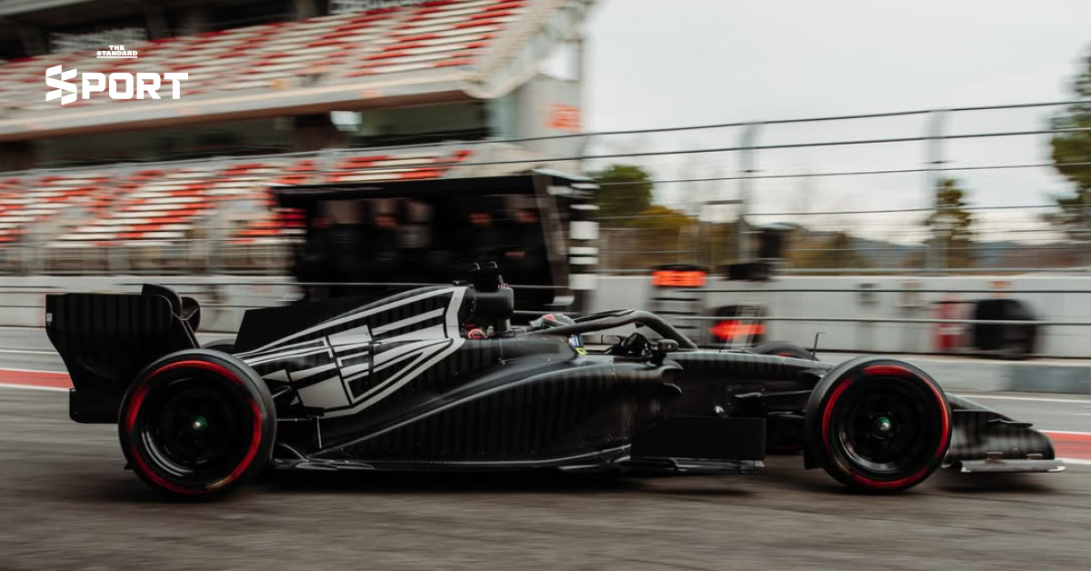 ภาพการแต่งกายของนักแข่งทีม Cadillac F1 พร้อมอุปกรณ์และโลโก้ทีมที่แสดงถึงสไตล์และความหรูหรา