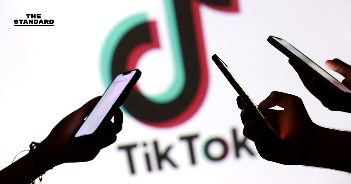 โลโก้ TikTok บนหน้าจอโทรศัพท์มือถือ โดยมีธงชาติสหรัฐฯ เป็นฉากหลัง สื่อถึงประเด็นการถูกแบนในสหรัฐฯ