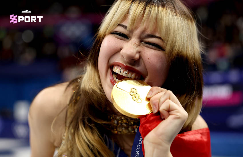 ภาพ Alysa Liu นักสเกตลีลาหญิงในชุดสีทองระยิบระยับ กำลังแสดงบนลานน้ำแข็งในโอลิมปิก 1