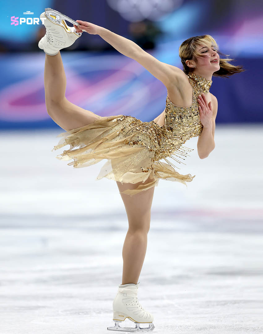 ภาพ Alysa Liu นักสเกตลีลาหญิงในชุดสีทองระยิบระยับ กำลังแสดงบนลานน้ำแข็งในโอลิมปิก 3