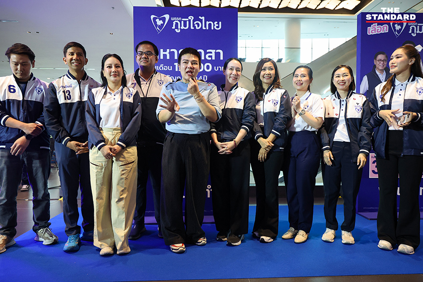 ประชาชนสวมเสื้อสีน้ำเงินร่วมฟังปราศรัยใหญ่พรรคภูมิใจไทย พร้อมถ่ายรูปกับป้ายนโยบายและภาพแกนนำ 5