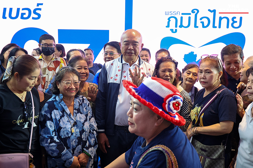 ประชาชนสวมเสื้อสีน้ำเงินร่วมฟังปราศรัยใหญ่พรรคภูมิใจไทย พร้อมถ่ายรูปกับป้ายนโยบายและภาพแกนนำ 8