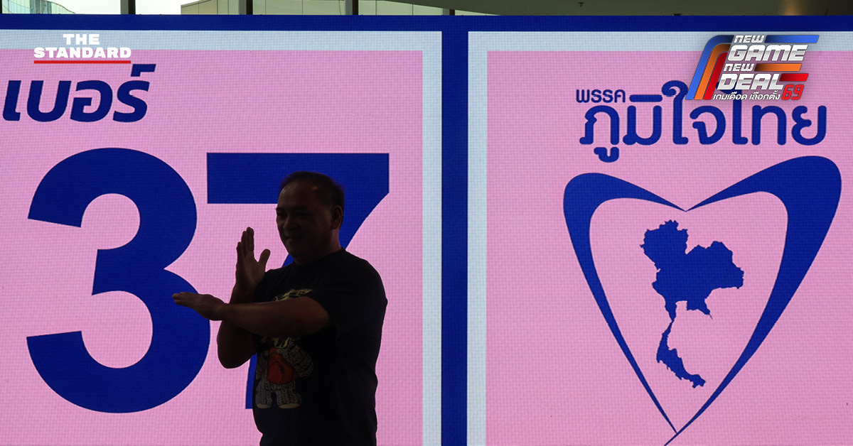 ประชาชนสวมเสื้อสีน้ำเงินร่วมฟังปราศรัยใหญ่พรรคภูมิใจไทย พร้อมถ่ายรูปกับป้ายนโยบายและภาพแกนนำ