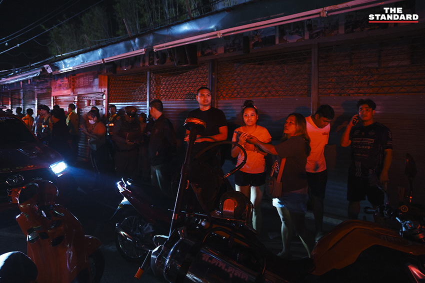 ภาพมุมกว้างเหตุเพลิงไหม้ร้านค้าในตลาดนัดจตุจักรยามค่ำคืน ขณะเจ้าหน้าที่ระดมกำลังฉีดน้ำสกัดเพลิง โดยมีควันไฟพวยพุ่งเหนือหลังคา 9