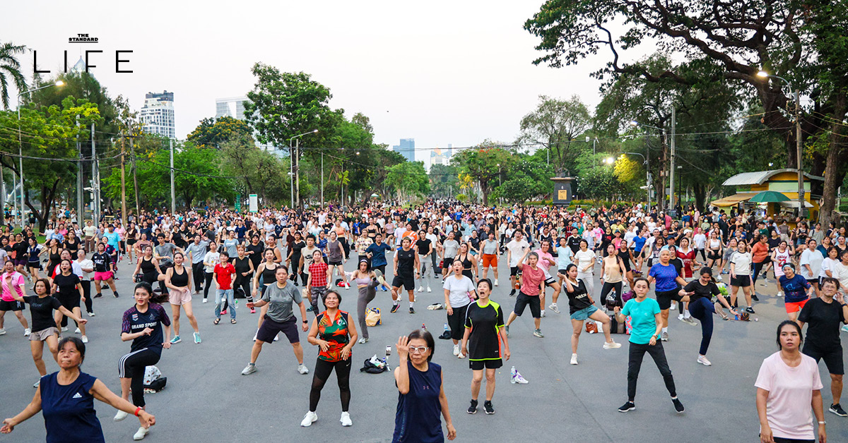ผู้คนเต้นแอโรบิกอย่างสนุกสนานที่ สวนลุมพินี พร้อมบรรยากาศยามเย็นและแก๊งแมว