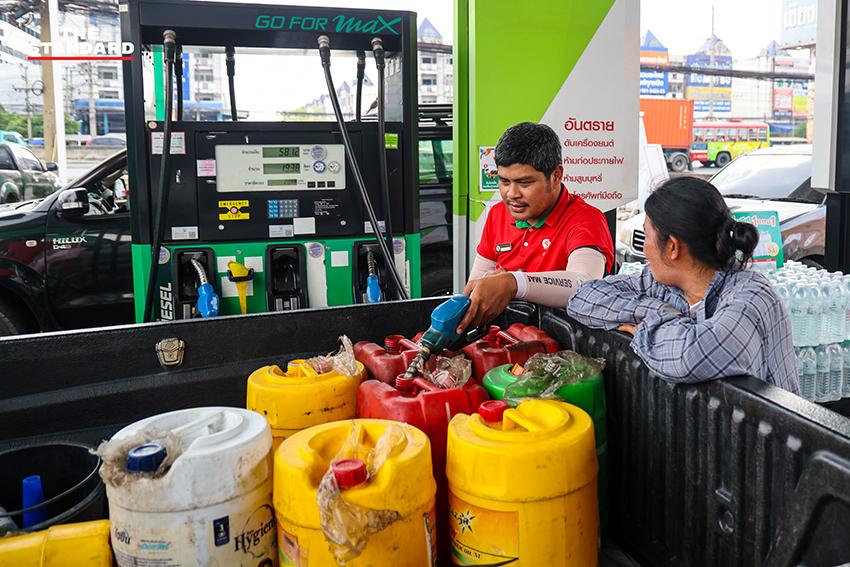 ภาพประชาชนนำแกลลอนและถังสำรองน้ำมันมาต่อคิวรอเติมน้ำมันที่สถานีบริการน้ำมันในจังหวัดปทุมธานี 1
