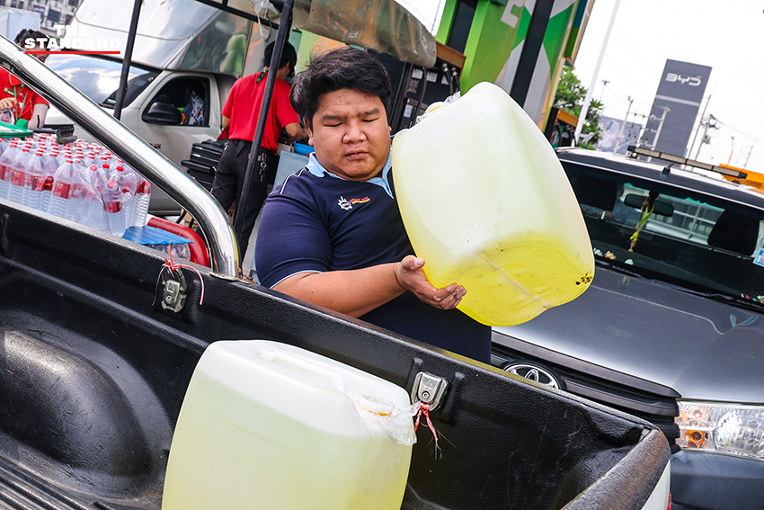 ภาพประชาชนนำแกลลอนและถังสำรองน้ำมันมาต่อคิวรอเติมน้ำมันที่สถานีบริการน้ำมันในจังหวัดปทุมธานี 4