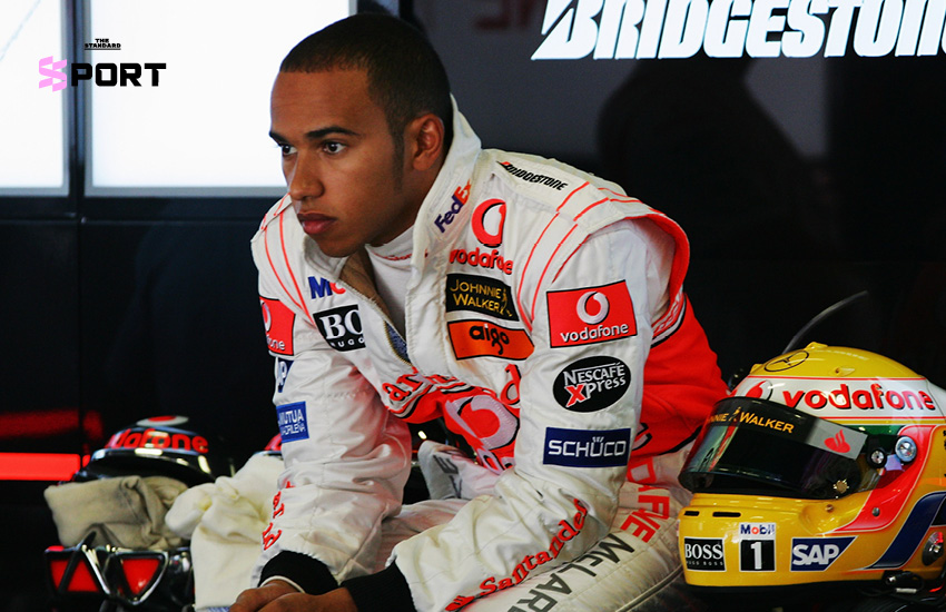 ลูอิส แฮมิลตัน ยืนยิ้มข้างรถแข่ง McLaren สีขาวแดง ในฤดูกาลเปิดตัวปี 2007 1