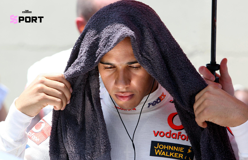 ลูอิส แฮมิลตัน ยืนยิ้มข้างรถแข่ง McLaren สีขาวแดง ในฤดูกาลเปิดตัวปี 2007 3