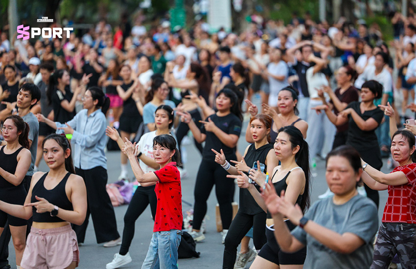 ภาพผู้คนกำลังเต้นแอโรบิกกลางแจ้งที่สวนลุมพินี โดยมีแมวมองดูเป็นกิมมิก 3