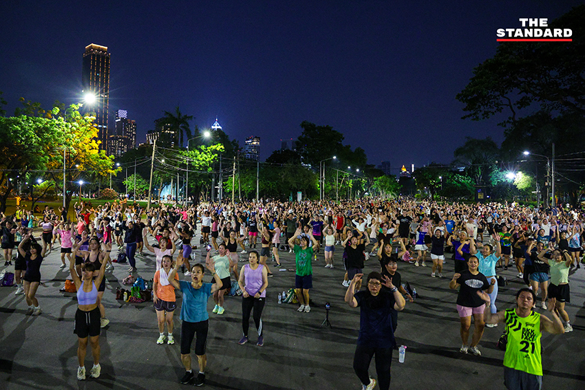 ภาพมุมกว้างของผู้คนจำนวนมากกำลังเต้นแอโรบิกอย่างสนุกสนานที่สวนลุมพินี 1