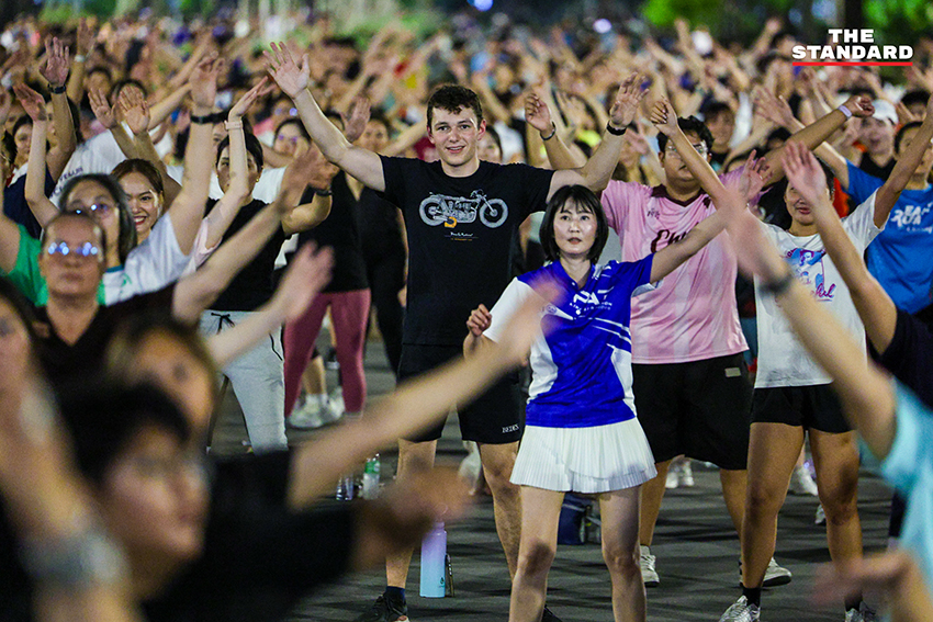 ภาพมุมกว้างของผู้คนจำนวนมากกำลังเต้นแอโรบิกอย่างสนุกสนานที่สวนลุมพินี 4