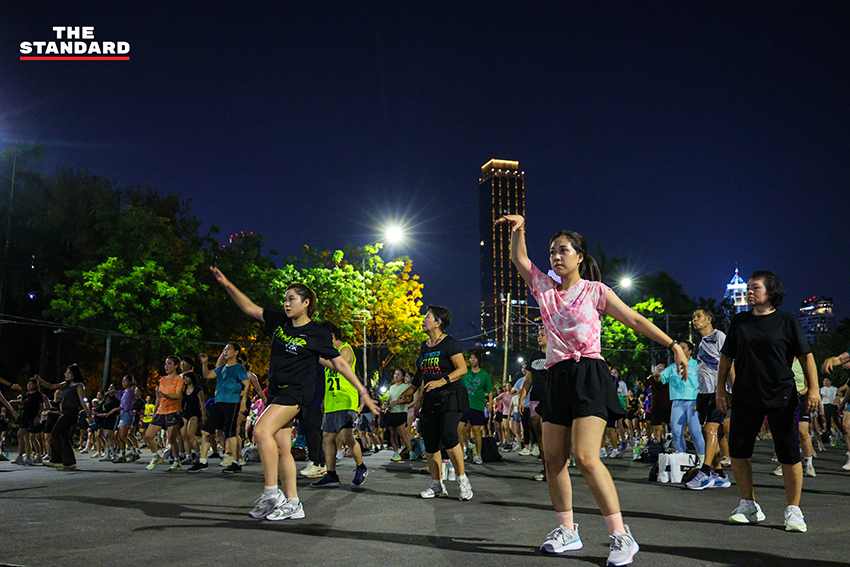 ภาพมุมกว้างของผู้คนจำนวนมากกำลังเต้นแอโรบิกอย่างสนุกสนานที่สวนลุมพินี 8