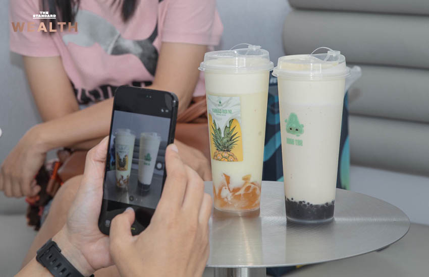 ธนกฤต ศรีพฤกษมาศ ผู้ก่อตั้ง Nose Tea ถ่ายภาพคู่เครื่องดื่มชาชีส พร้อมโลโก้จมูกสีเขียวอันเป็นเอกลักษณ์ของแบรนด์ 2