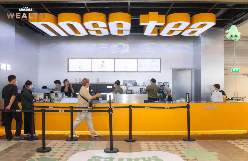 ธนกฤต ศรีพฤกษมาศ ผู้ก่อตั้ง Nose Tea ถ่ายภาพคู่เครื่องดื่มชาชีส พร้อมโลโก้จมูกสีเขียวอันเป็นเอกลักษณ์ของแบรนด์ 6