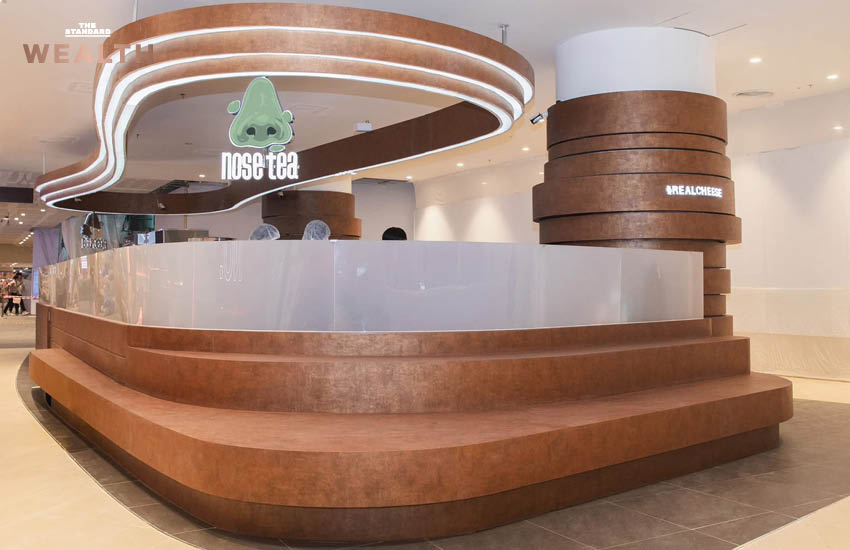 ธนกฤต ศรีพฤกษมาศ ผู้ก่อตั้ง Nose Tea ถ่ายภาพคู่เครื่องดื่มชาชีส พร้อมโลโก้จมูกสีเขียวอันเป็นเอกลักษณ์ของแบรนด์ 7