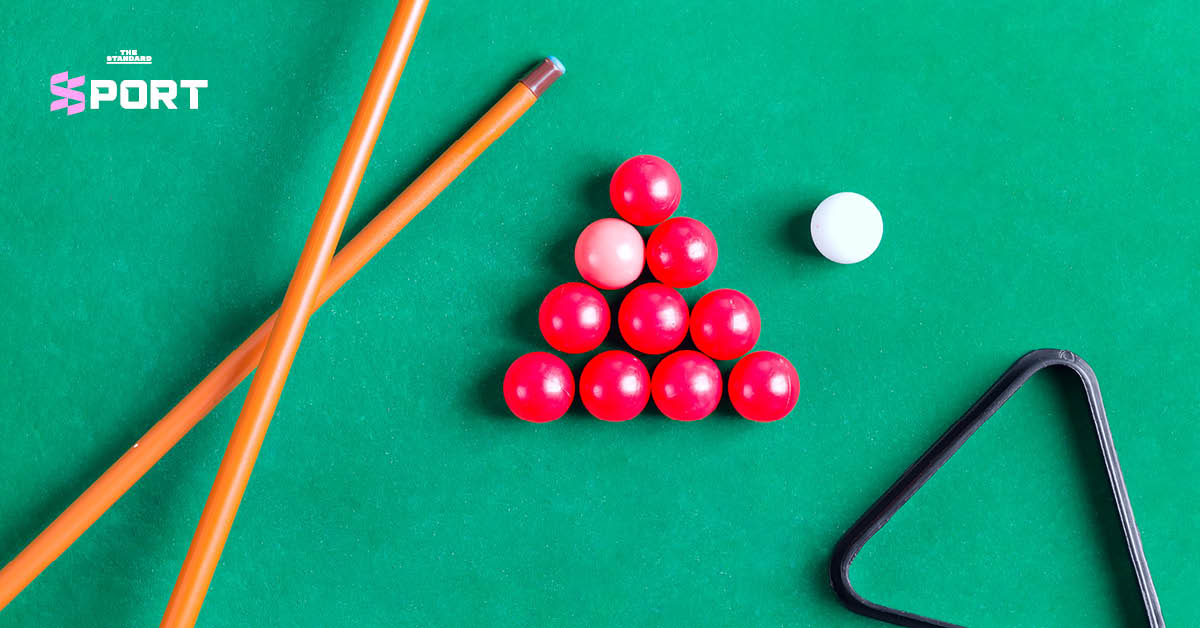 ลูกสนุกเกอร์หลากสีและไม้คิวบนโต๊ะบิลเลียดสีเขียว