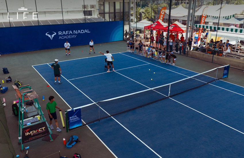 ภาพสนามเทนนิส ALM x Impact Tennis ใหม่ในย่านเมืองทองธานี พร้อมผู้คนกำลังเล่นเทนนิส 1