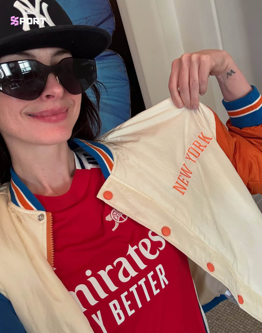 แอนน์ แฮทธาเวย์ ยืนบนพื้นหลังลายธงสโมสรอาร์เซนอล 1