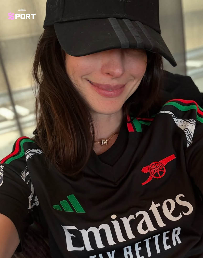 แอนน์ แฮทธาเวย์ ยืนบนพื้นหลังลายธงสโมสรอาร์เซนอล 2