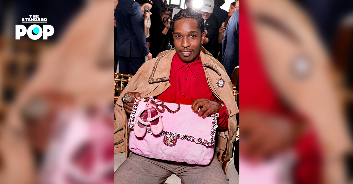 A$AP Rocky ในชุดแจ็กเกตหนังกลับสีน้ำตาล ถือกระเป๋าสีชมพูใบใหญ่ พร้อม รองเท้าบัลเลต์คู่จิ๋วห้อยอยู่ ที่งาน CHANEL Cruise