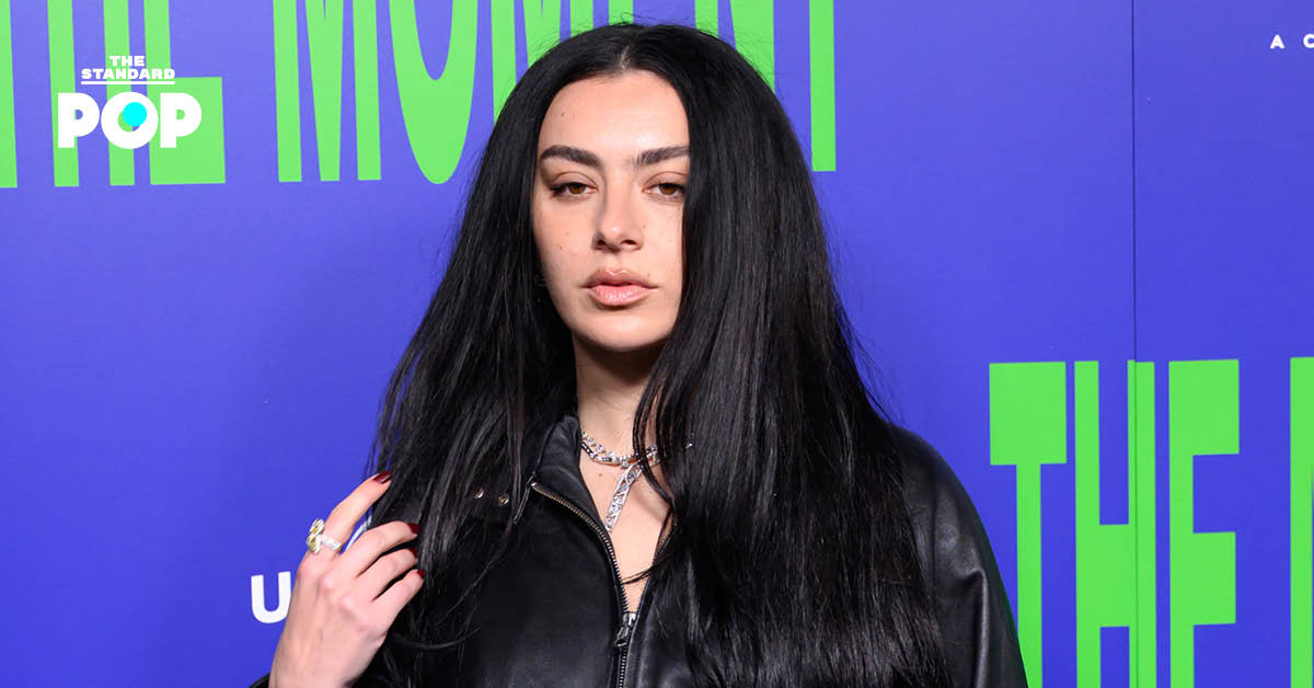 ชาร์ลี XCX ศิลปินป๊อปชาวอังกฤษ ในชุดสีดำกำลังโพสท่าระหว่างเข้าร่วมงานอีเวนต์