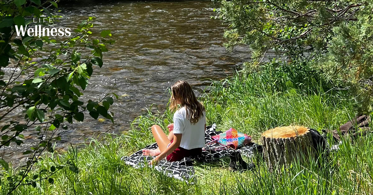 ภาพผู้หญิงและสุนัขกำลังพักผ่อนริมทะเลสาบ สะท้อนช่วงเวลาแห่งความสุขและผ่อนคลาย