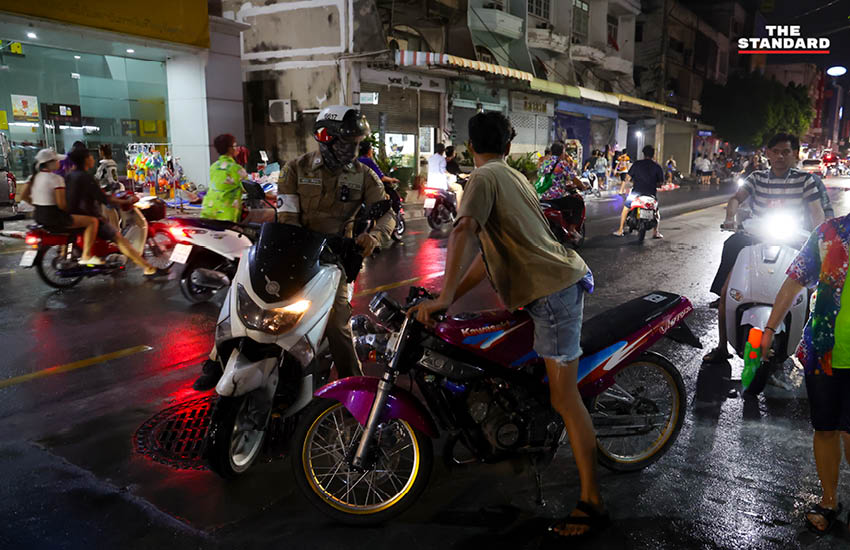 บรรยากาศผู้คนเล่นน้ำสงกรานต์อย่างคึกคักที่ถนนโชคชัย 4 พร้อมรถจักรยานยนต์และเสียงเพลง 2