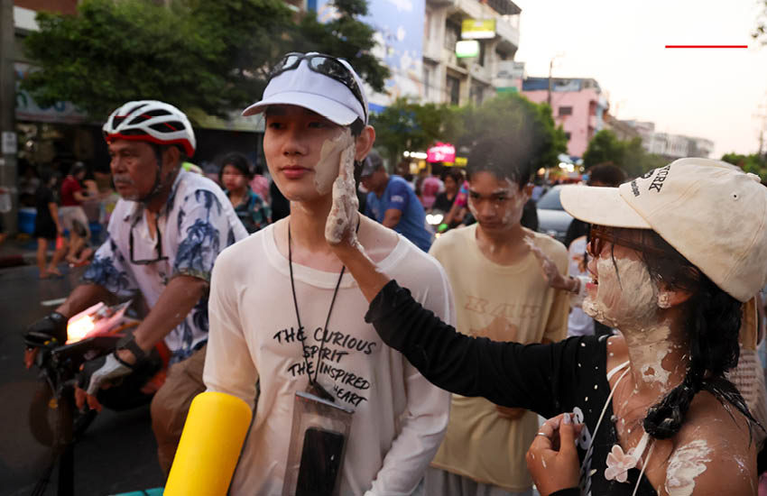 บรรยากาศผู้คนเล่นน้ำสงกรานต์อย่างคึกคักที่ถนนโชคชัย 4 พร้อมรถจักรยานยนต์และเสียงเพลง 20