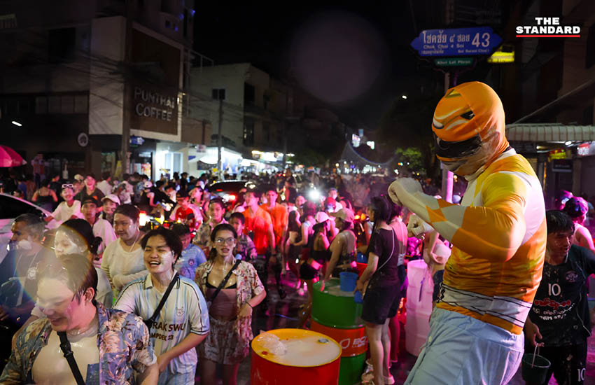 บรรยากาศผู้คนเล่นน้ำสงกรานต์อย่างคึกคักที่ถนนโชคชัย 4 พร้อมรถจักรยานยนต์และเสียงเพลง 3