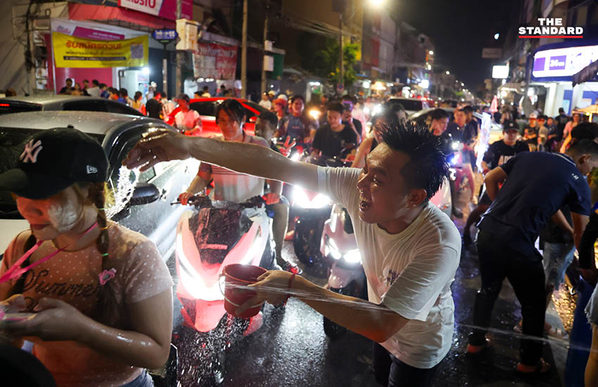 บรรยากาศผู้คนเล่นน้ำสงกรานต์อย่างคึกคักที่ถนนโชคชัย 4 พร้อมรถจักรยานยนต์และเสียงเพลง 7