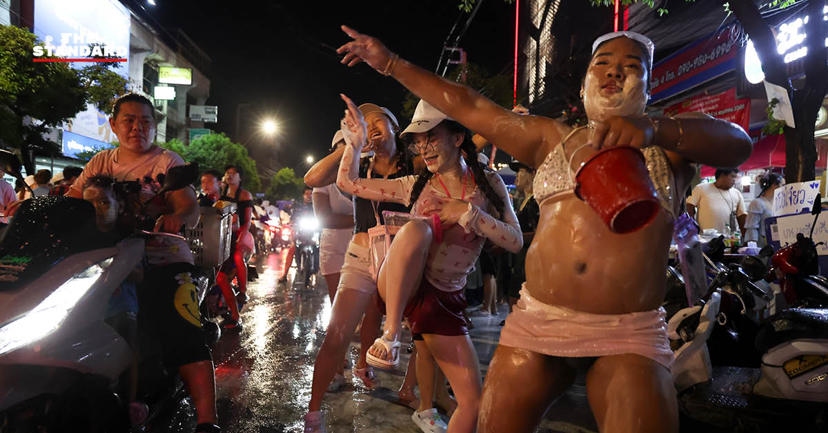 บรรยากาศผู้คนเล่นน้ำสงกรานต์อย่างคึกคักที่ถนนโชคชัย 4 พร้อมรถจักรยานยนต์และเสียงเพลง