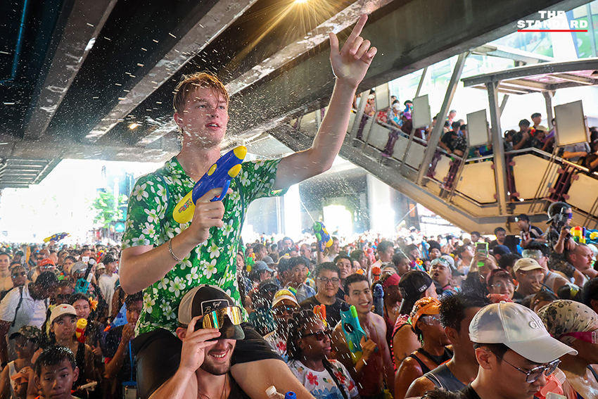 ภาพมุมสูงแสดงถนนสีลมเต็มไปด้วยผู้คนและกิจกรรมการเล่นน้ำในเทศกาลสงกรานต์อย่างคึกคัก 1