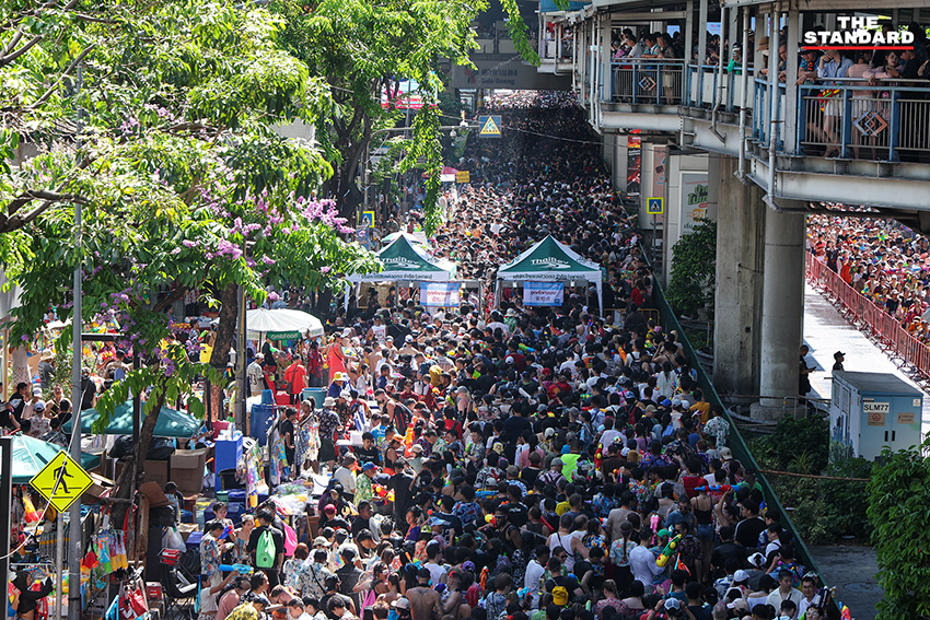ภาพมุมสูงแสดงถนนสีลมเต็มไปด้วยผู้คนและกิจกรรมการเล่นน้ำในเทศกาลสงกรานต์อย่างคึกคัก 6
